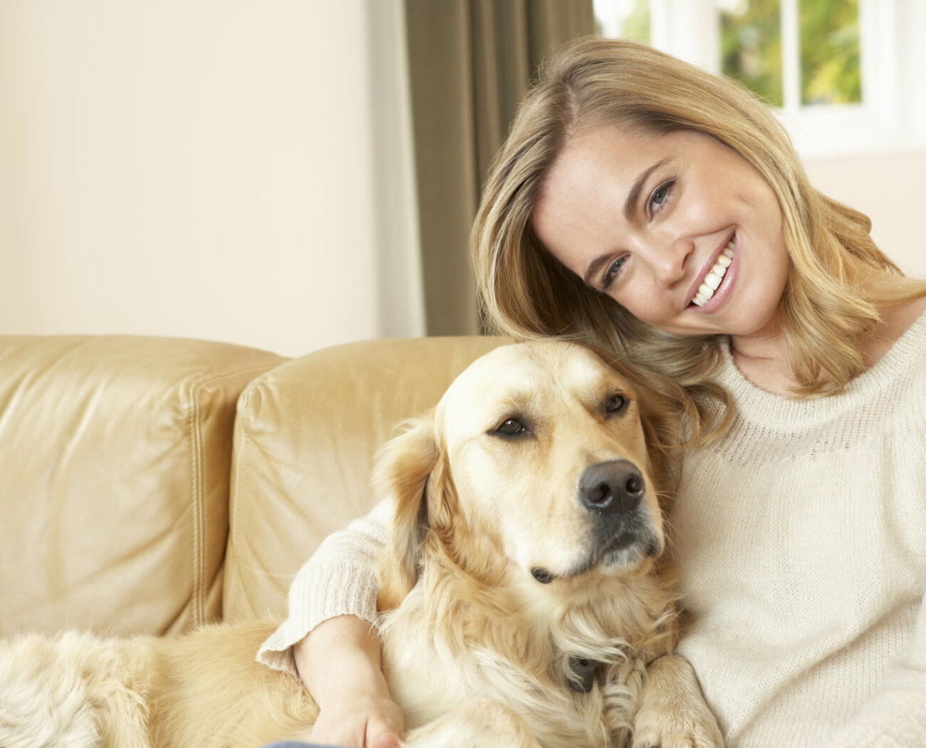 Young woman with dog sitting on sofa